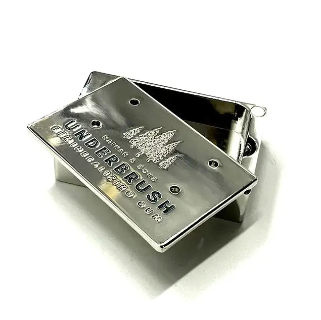 Stainless Slide Snap Gum Case featuring the UNDERBRUSH logo and engraved pine tree design. The lid is partially open, showcasing the interior compartment.