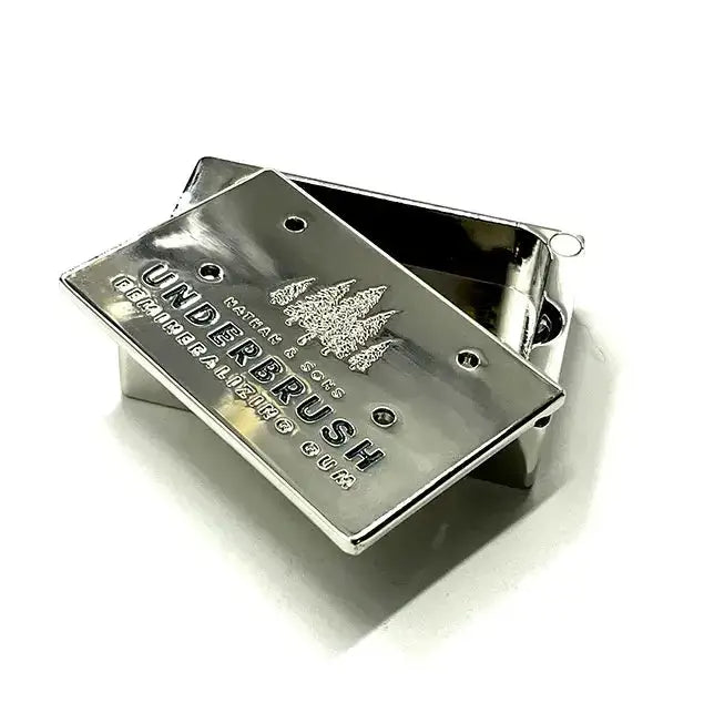 Stainless Slide Snap Gum Case featuring the UNDERBRUSH logo and engraved pine tree design. The lid is partially open, showcasing the interior compartment.