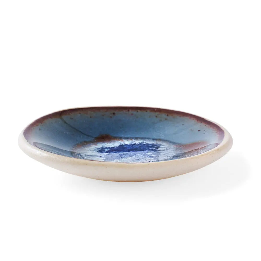 Frontal view of Underbrush handmade ceramic gum dish with a batik blue glaze flowing pattern