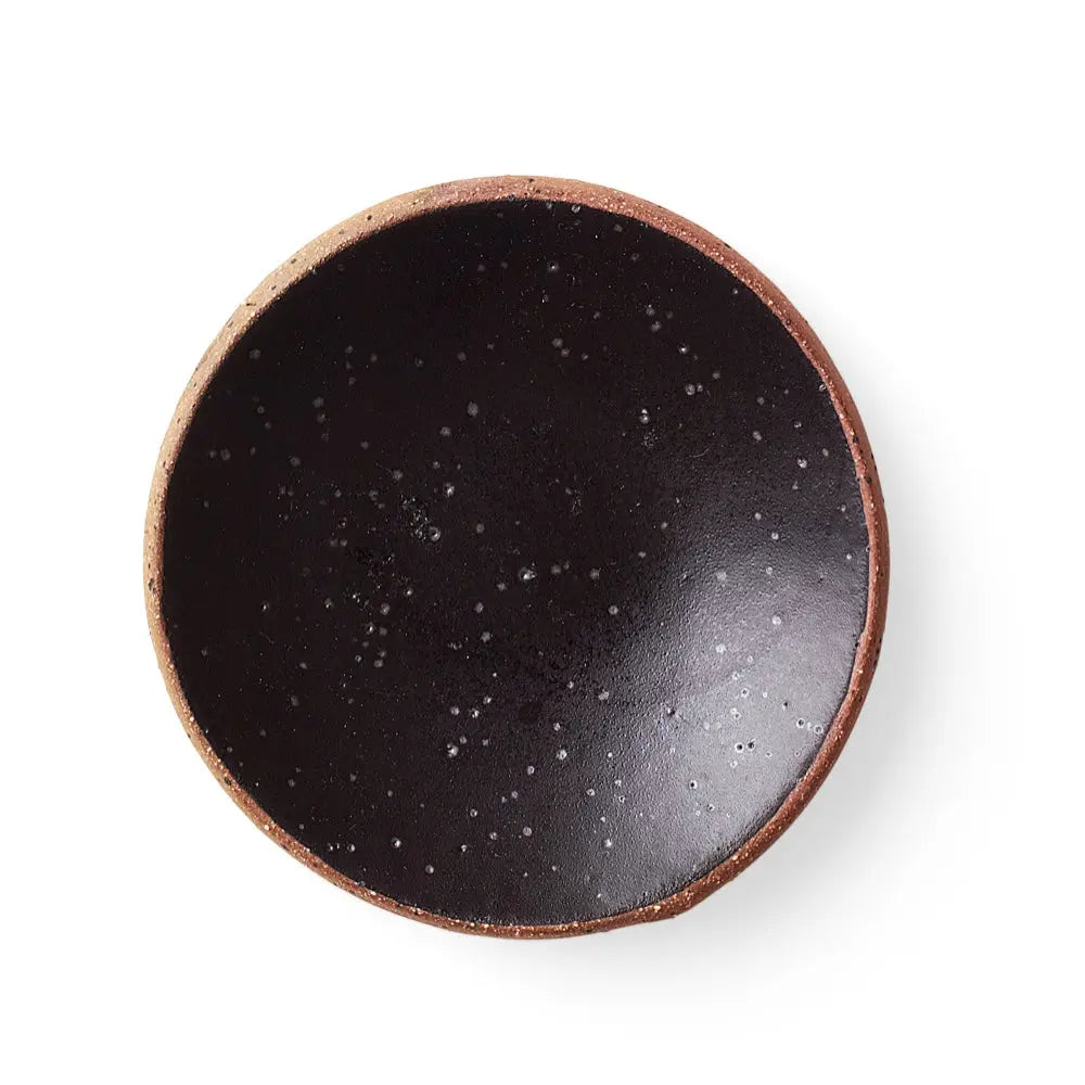 Top-down view of a handmade ceramic gum dish in a deep Noir glaze, featuring a matte black finish with subtle speckling and a clay rim