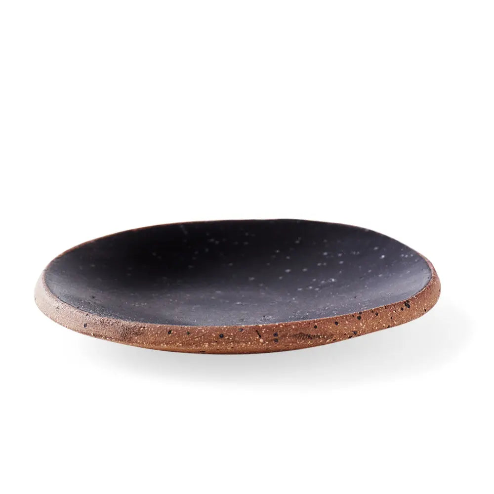 Frontal view of a handmade ceramic gum dish in a deep Noir glaze, featuring a matte black finish with subtle speckling and a clay rim