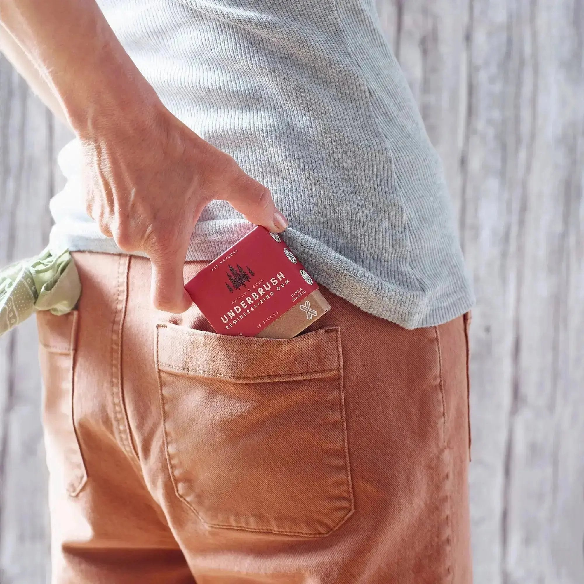 Underbrush cinna mastic remineralizing gum being placed in back pocket