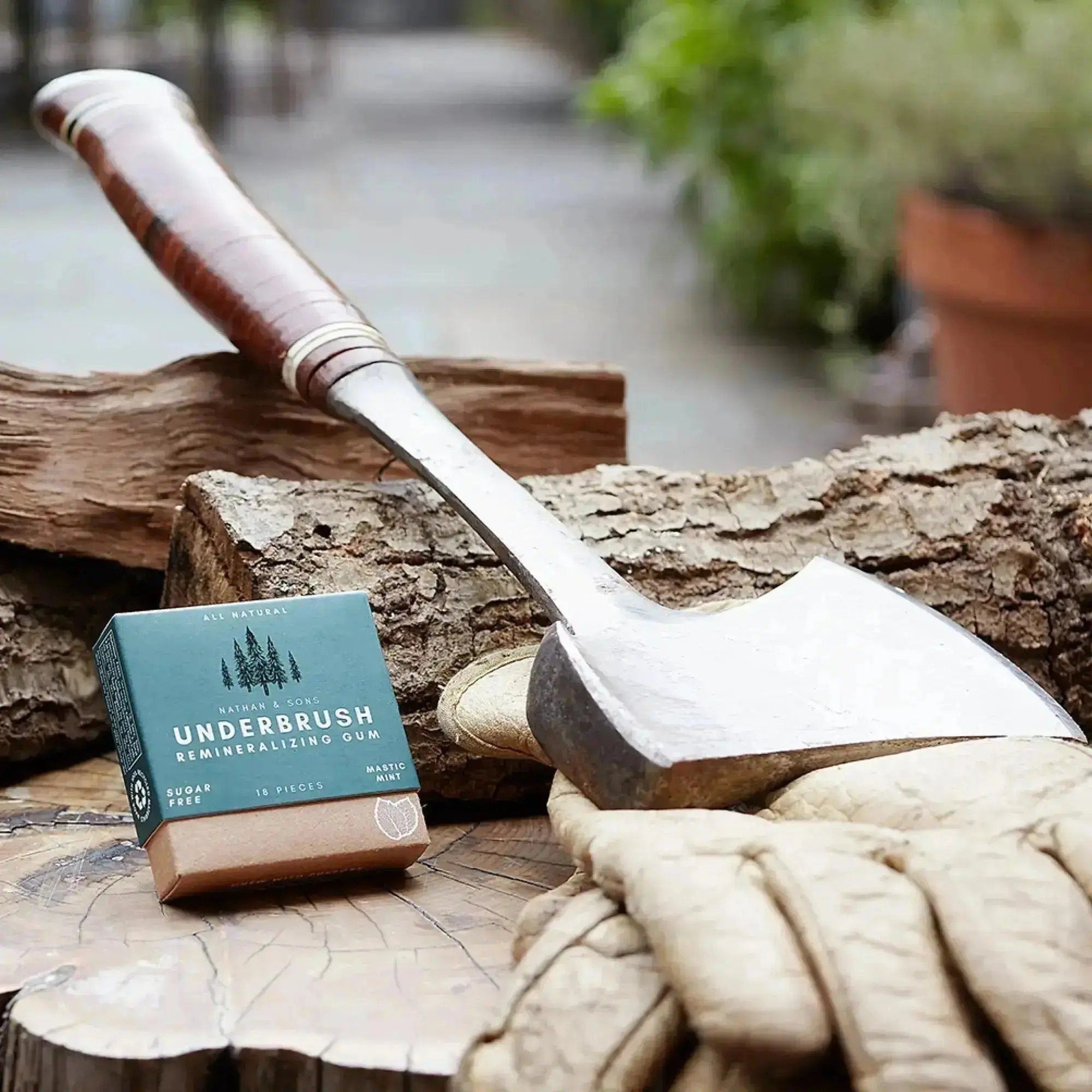 Nathan and Sons Underbrush Mastic Mint flavor gum displayed on chopped firewood with axe and gloves