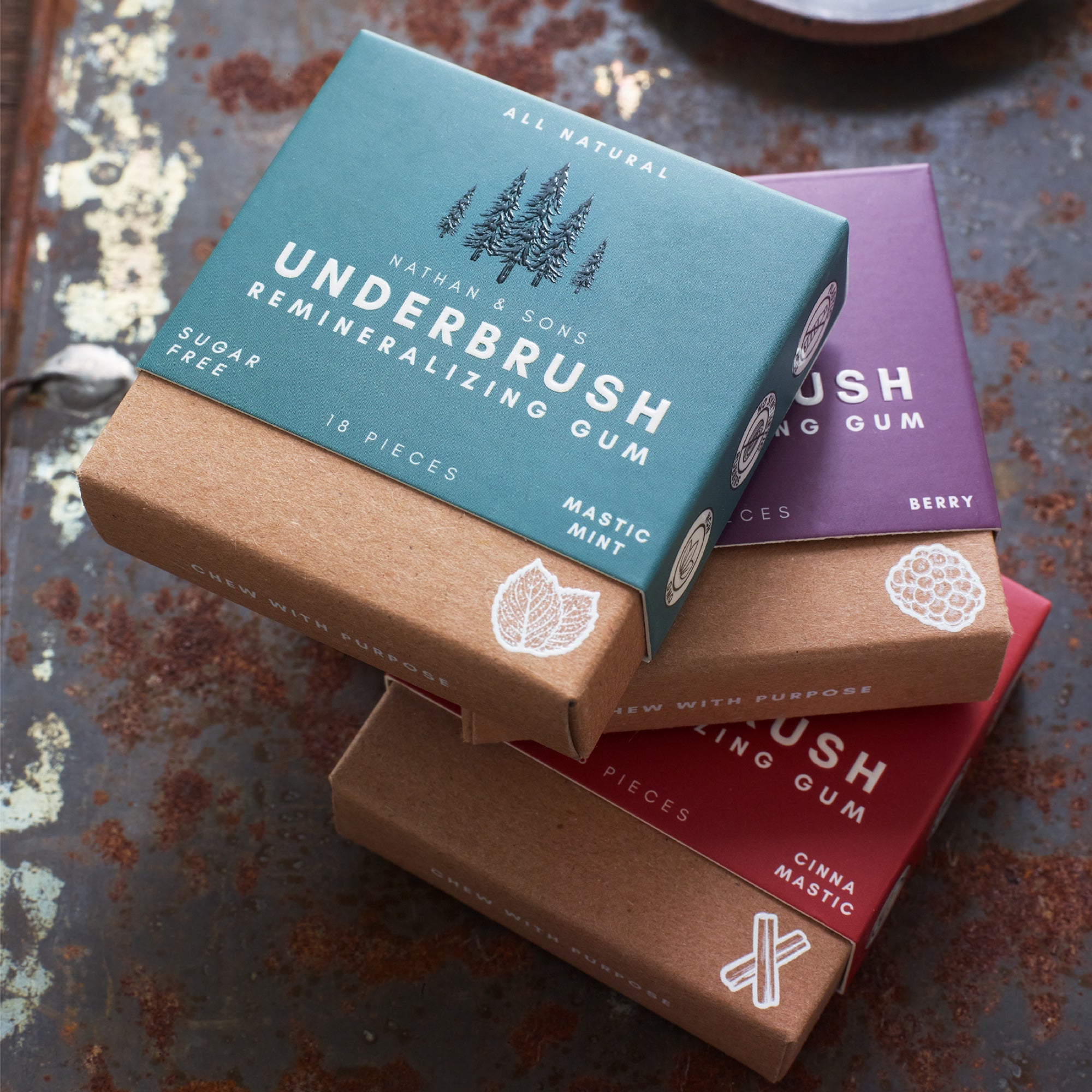 Boxes of xylitol chewing gum with mint, berry and cinnamon flavor stacked on top of each other.